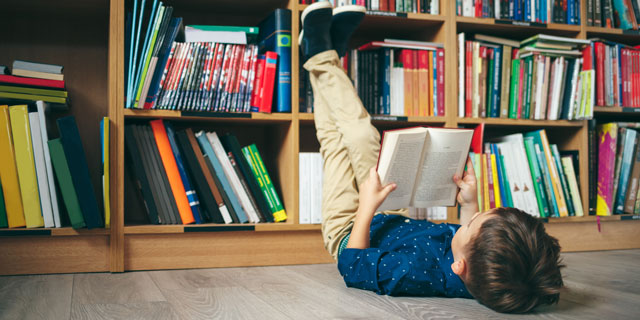 دانش آموز در حال جستجو درکتاب ها برا پیدا کردن جواب